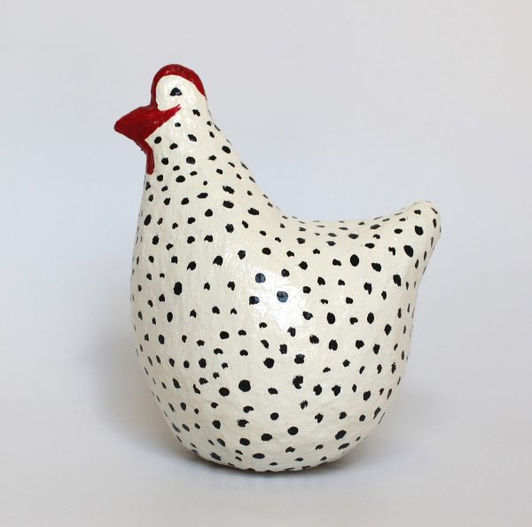 תרנגולת לבנה עם נקודות שחורות.
